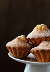 Fresh vanila cupcakes on a white platter. Fragrant creamy cupcakes on a dark background. A place to copy.