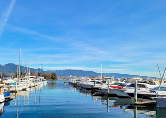 Boats dock at the Coal Harbour Marina in the Vancouver Bay, outside of the city of Vancouver, BC Canada