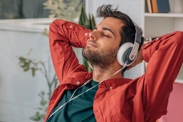 man at home resting listening to music relaxed