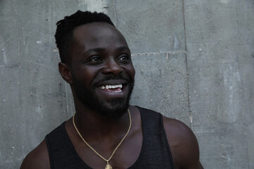Obraz premium Headshot of Black young man smiling and posing over concrete background.