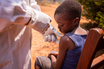 Close-up of a doctor injecting the vaccine to a child in africa - obrazy, fototapety, plakaty