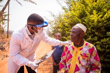 Foto op Canvas African doctor visits an elderly patient and they converse during the medical examination. Health care in africa concept © Media Lens King