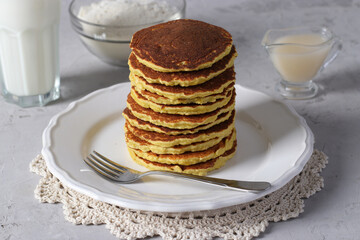 Coconut flour pancakes on white plate on light gray background, vegan food