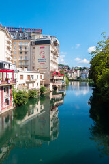 Lourdes, France - August 28, 2021: Cityscape of Lourdes with hotels and residential buildings on the banks of the river Ousse