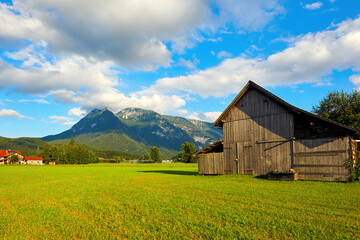Obraz premium Beautiful Austrian Landscape with agricultural field, old barn and mountains. Bad Goisern, Upper Austria. 