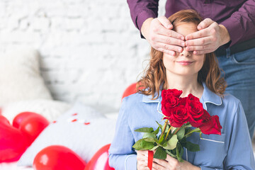 Happy couple on Saint Valentine's Day morning. Man making surprise. Woman smiling