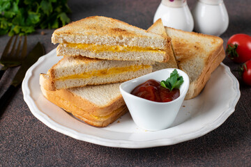 Sandwiches with egg and cheese fried in pan served with tomato sauce for breakfast