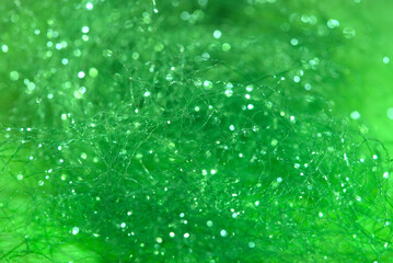 tangled shiny green synthetic fiber background in macro shot