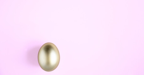 Golden shiny easter egg on pink pastel background