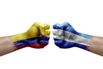 Two hands punch to each others on white background. Country flags painted fists, conflict crisis concept between colombia and nicaragua - obrazy, fototapety, plakaty