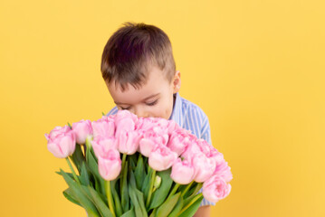 Cute little boy with a bouquet of flowers. Tulips. mothers Day. International Women's Day. Portrait of a happy little boy. Spring