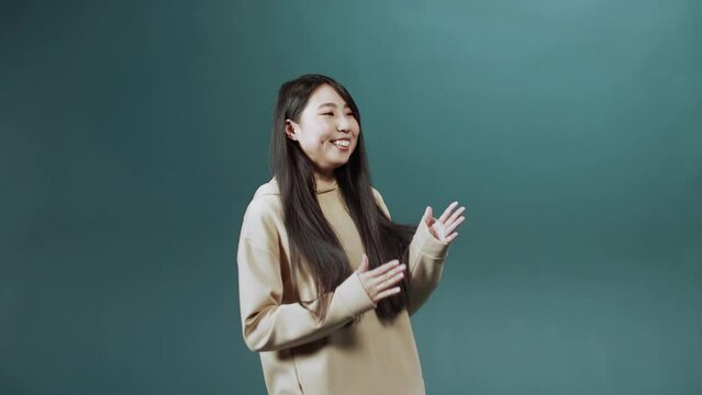 A young asian lady is dancing delightfully in slow motion