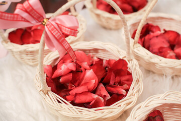 Basket of red rose petals in wedding ceremony. Close-up, copy space, toned. wedding decoration.