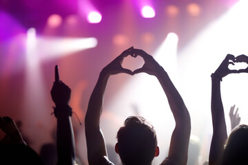 Showing some love for the band. Rearview of people in the audience at a music concert holding up...