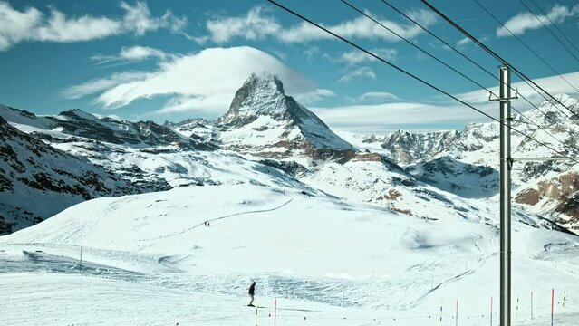Scenic Panoramic view of Mount Matterhorn in the Swiss Alps, Zermatt in 4K. Beautiful view of people skiing at one of the highest summits in the Alps and Europe, view from Gornergrat, Switzerland.