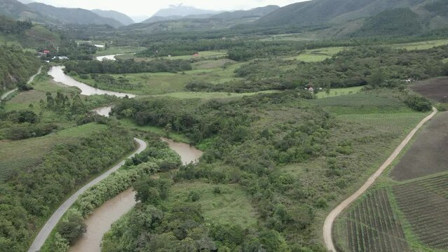 Aerial tilt to winding Huancabamba River in cloudy green valley, Peru