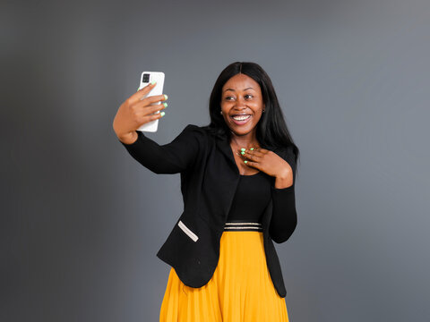 portrait picture of young beautiful African businesswoman taking picture with mobile phone