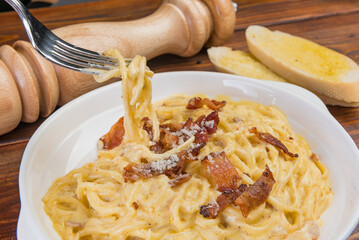 carbonara with bacon on wood background, pasta