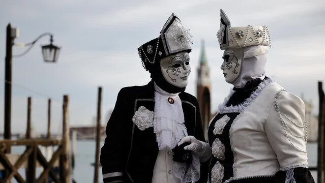 Venice, Italy - February 2022 - carnival masks are photographed with tourists in San Marco square