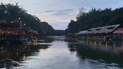 Fototapeta premium Baan rafts by the water on both sides of the road Start lighting the lanterns. In the evening, the shadow of the house falls on the water.