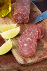 Sliced and whole Italian salami on cutting board.