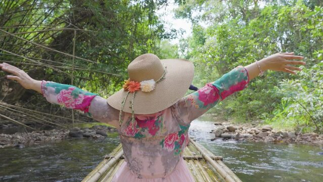 asian women traveler on bamboo rafting river forest. 