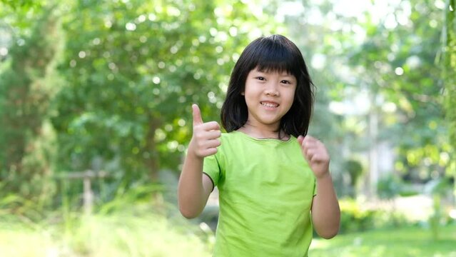 portrait asian kid, child enjoy and happy, the girl is smiling, thumbs up kid
