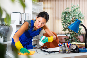 Positive asian woman worker wearing uniform cleaning at company office