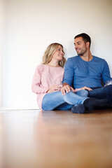 Happy in their new home. Shot of a happy young couple sitting on their living room floor.