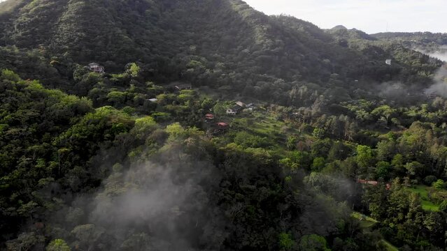 Low clouds over homes in Valle de Anton in central Panama extinct volcano crater valley, Aerial dolly right shot