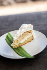 Coconut cake on white plate on the wooden table