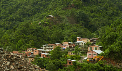 Fototapeta na wymiar Small houses surrounded by forested hills