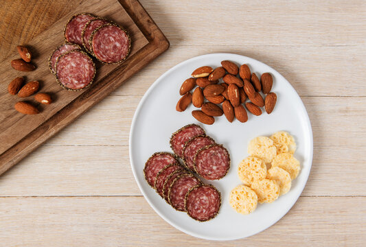 Appetizer snack of salami, almonds and Parmesan crisps  
