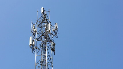 Cellular Base Station Tower. The base station is equipped with 4G and 5G wireless radio and cellular communication technology with a clear sky background with copy space. Selective focus