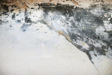 The texture of the concrete wall with partially washed away plaster, water damage and mold. Front view.