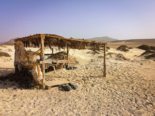 Wild camping place in Cape Verde. Small wooden structured in the middle of a desert. Clear blue sky, hot weather. Selective focus on the details, blurred background.