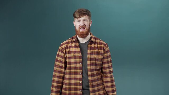 Carefree stylish white-skinned young guy in checkered shirt with thumbs-up sign