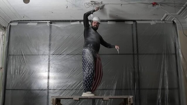 cheerful man in a construction uniform and a white helmet,dancing