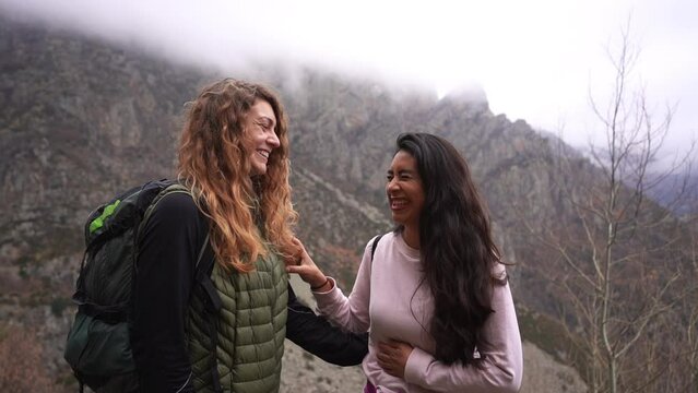 multiracial mixed race couple of close best friends share time together laughing and enjoying life during a backpacking trekking trip in remote mountain wilderness