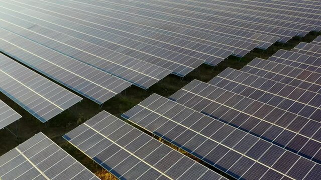 Slow motion shot, Aerial drone view, Flight over solar panel farm, Renewable green alternative energy by solar cell panels with sunlight