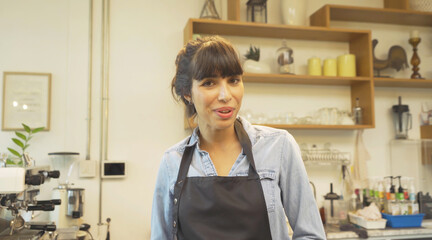 Portrait of Asian woman barista people in apron selling products online via live e-commerce live or conference sales social media, cafe restaurant cashier. waitress in coffee shop. People lifestyle.
