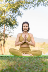 Young attractive and active woman practicing her morning yoga outdoor at a local lake park