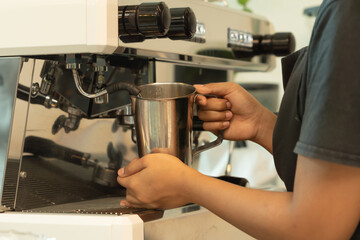 Close up of woman worker, barista in apron making a coffee by using coffee machine in kitchen bar of coffee shop. Business service. People lifestyle.