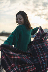Obraz premium 夕暮れの河川敷にいる女性