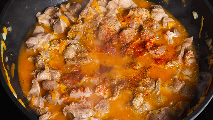 Close-up of Chicken Gizzard stewed in a wok with vegetables sprinkled with paprika. Top view. Asian-style cooking.