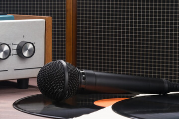 the microphone lies on a vinyl record in front of an old record player