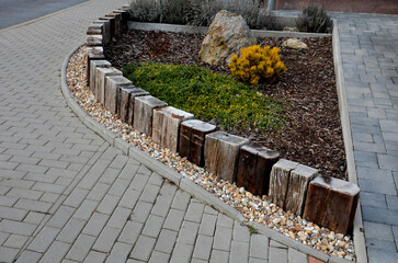a colorful perennial flowerbed at the entrance to the garden bordered by a decorative wooden...