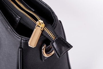 The details and workmanship of a black leather bag are on a white background