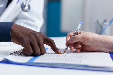 Close up of woman hand signing healthcare coverage policy and prescripted medication. Hospital...