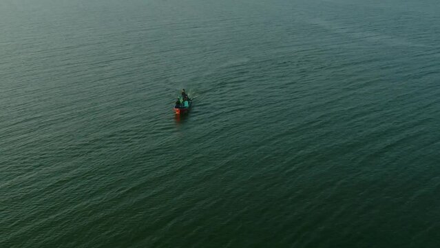 Aerial shot of Speeding Patrolling Boat At Keenjhar Lake In Thatta, Pakistan at sunset.